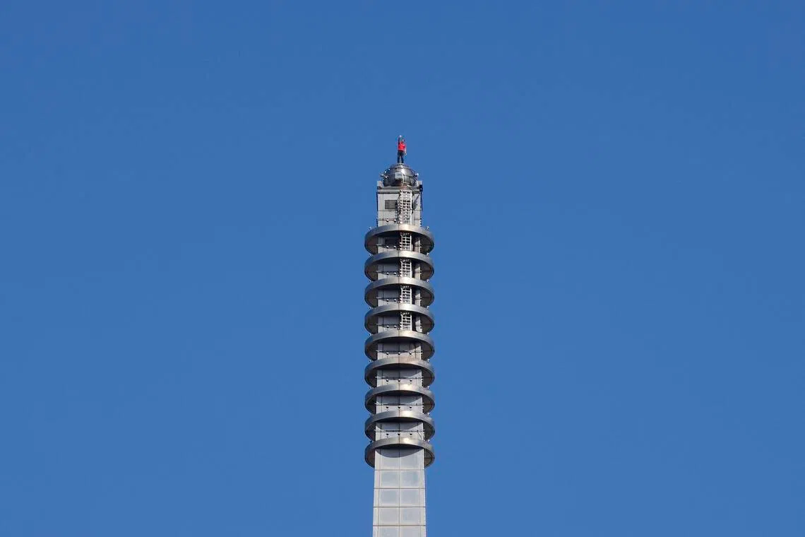 American climber Alex Honnold waving from the top of Taipei 101 on Jan 25.
