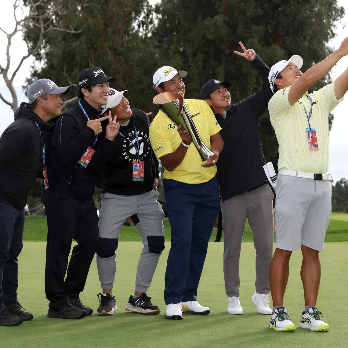 Hideki Matsuyama of Japan posing for a wefie with his caddie Shota Hayafuji and friends after his winning putt on the 18th green during the final round of The Genesis Invitational.