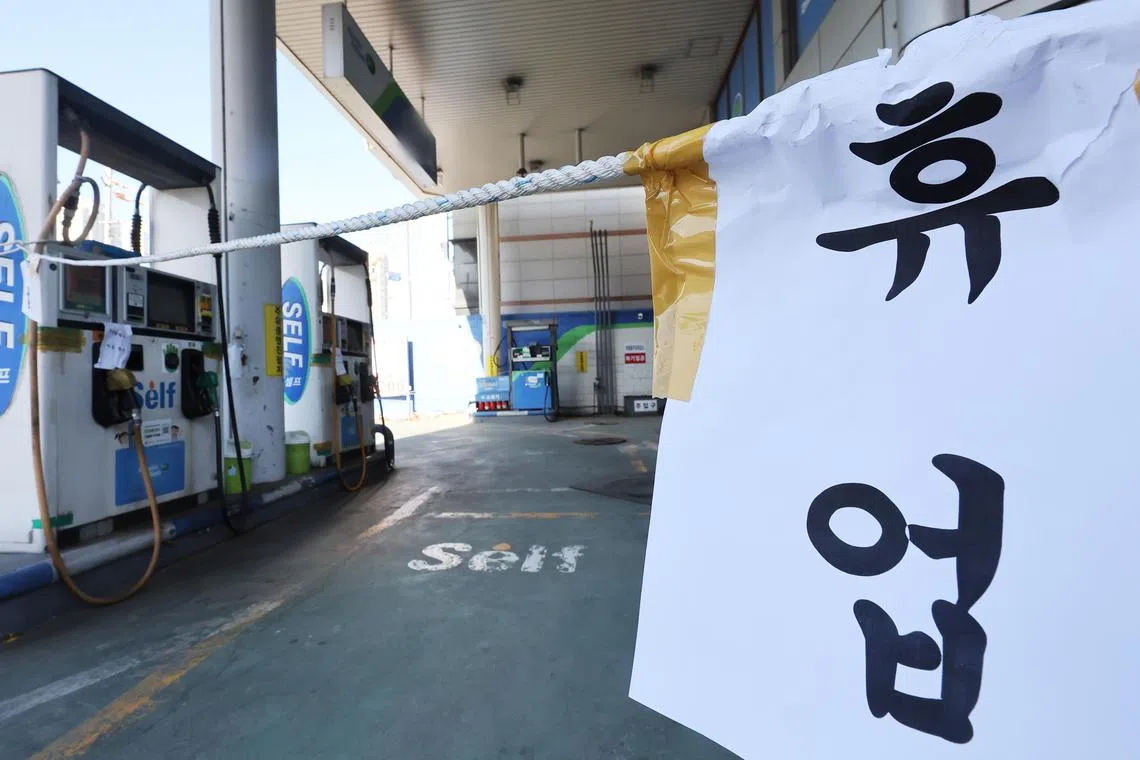 epa10349051 A notice reading 'Temporary Closure' is posted at a gas station in Seoul, South Korea, 05 December 2022, amid a nationwide strike by unionized truckers that has disrupted supply chains in the country's key industries. About 80 percent of drivers of oil trucks are unionists. Truck drivers went on strike on 24 November, demanding the government extend temporary rules guaranteeing minimum freight rates, citing high fuel prices.  EPA-EFE/YONHAP SOUTH KOREA OUT