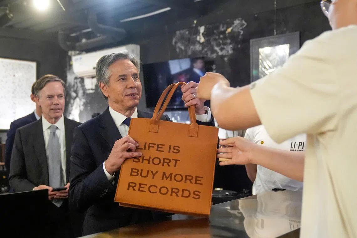 U.S. Secretary of State Antony Blinken takes a bag after buying records during a visit to Li-Pi record store in Beijing, China, April 26, 2024.     Mark Schiefelbein/Pool via REUTERS