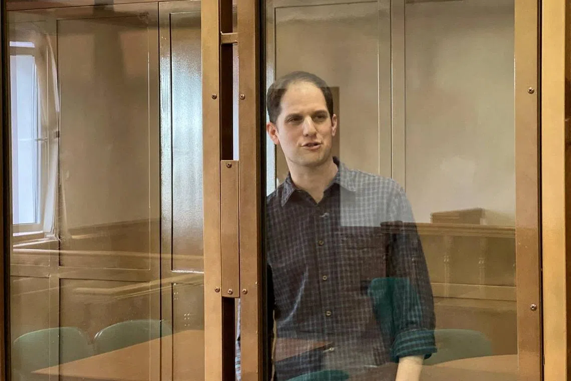 FILE PHOTO: Wall Street Journal reporter Evan Gershkovich, who is in custody on espionage charges, stands behind a glass wall of an enclosure for defendants as he attends a court hearing to consider extending his detention in Moscow, Russia, March 26, 2024. Moscow City Court's Press Office/Handout via REUTERS/File Photo