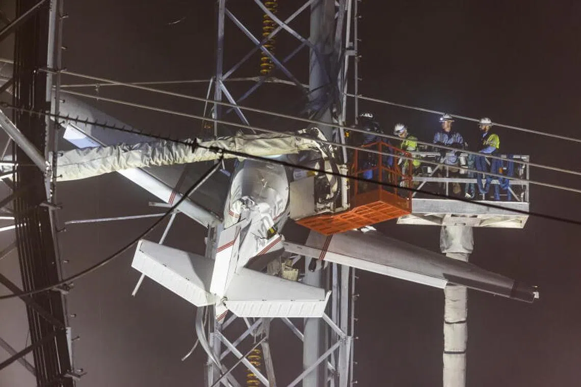 Rescue workers attempt to free the pilot and passenger of a small plane that crashed into a power line, knocking out electricity for tens of thousands of residents, in Gaithersburg, Maryland, USA on 28 November 2022.  PHOTO : EPA-EFE
