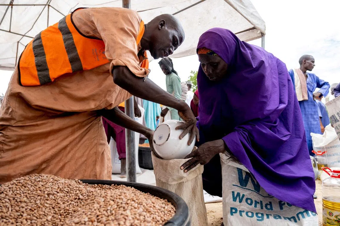 FILE PHOTO: Yaanama Abba, a 45-year-old mother of six children, receives pinto beans distributed by WFP in Mafa LGA, Borno State, Nigeria, July 16, 2025. Damilola Onafuwa, WFP Nigeria Communications Service/Handout via REUTERS/File Photo