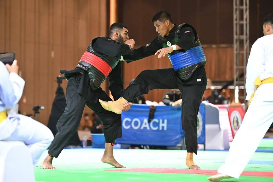 Singapore's Sheik Farhan Bin Sheik Alau'ddin (red) in action against Malaysia's Muhammad Robial Sobri, on May 10, 2023.