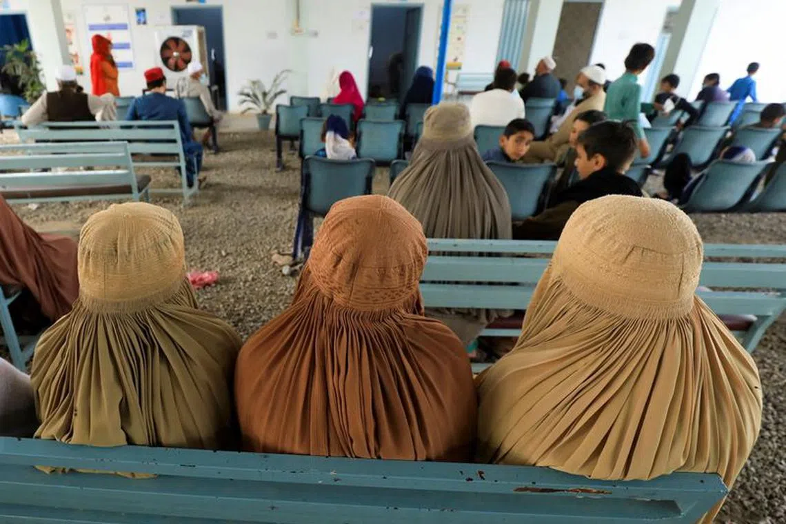 FILE PHOTO: Afghan women who are living in Pakistan wait to get registered during a proof of registration drive at United Nations High Commissioner for Refugees (UNHCR) office in Peshawar, Pakistan September 30, 2021. REUTERS/Fayaz Aziz/File Photo