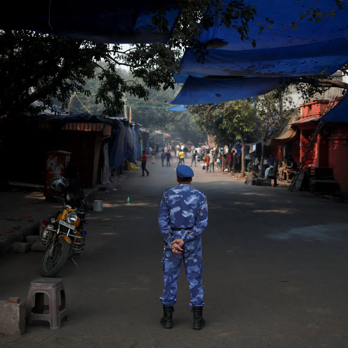 A security personnel stands guard at a closed market area near the site of an explosion, near the historic Red Fort in the old quarters of Delhi, India, November 12, 2025. REUTERS/Adnan Abidi