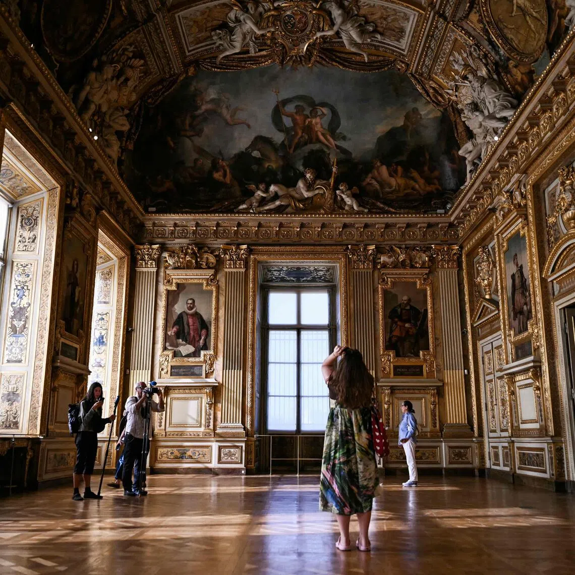 Visitors taking a photo of the window which was broken during the reopening to the public of the Apollo Gallery, where French crown jewels worth €88 million were stolen in 2025 in a brazen heist, at the Musée du Louvre in Paris on July 22.