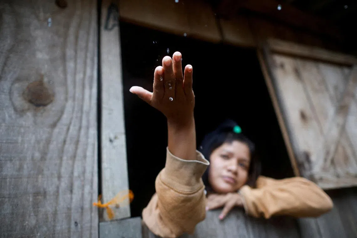 Pailona Ramirez from Guarani indigenous tribe, looking on during rain at Pindo Poty village after it was flooded, in Porto Alegre, Rio Grande do Sul state, Brazil May 13, 2024.