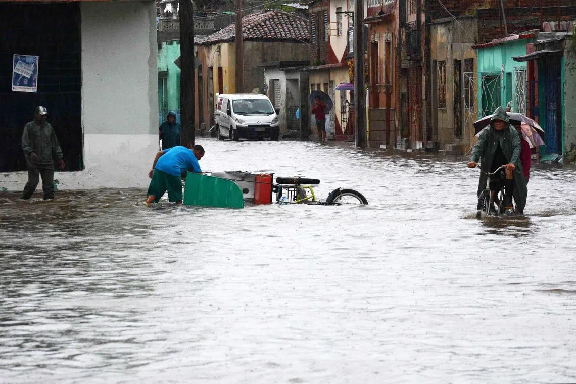 In this handout picture released by ACN people are seen on a street after heavy rains caused a flood in Camaguey, Cuba on June 9, 2023. The heavy rains of the last few days have caused floods in various provinces in central and eastern Cuba, with the death of one person, thousands of evacuees and numerous material damages, authorities reported on Saturday. (Photo by Rodolfo BLANCO CUE / ACN / AFP) / RESTRICTED TO EDITORIAL USE - MANDATORY CREDIT "AFP PHOTO / ACN (CUBAN NEWS AGENCY) / RODOLFO BLANCO CUE" - NO MARKETING NO ADVERTISING CAMPAIGNS - DISTRIBUTED AS A SERVICE TO CLIENTS