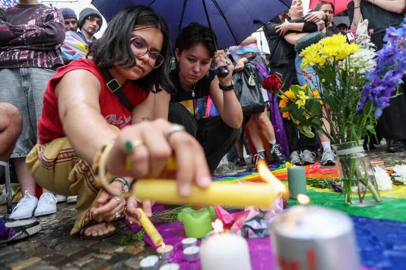 A girl lights a candle as people gather at Brandenburg Gate, after a deadly incident in which a vehicle crashed into a crowd near Berlin's annual Christopher Street Day Pride parade on Saturday evening, leaving multiple people injured and the parade called off, in Berlin, Germany, July 26, 2026. REUTERS/Maryam Majd