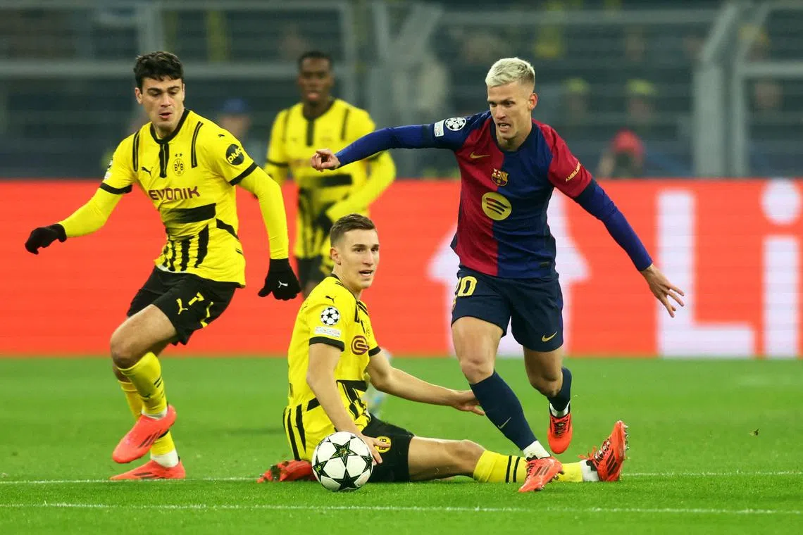 Barcelona's Dani Olmo fighting for the ball with Borussia Dortmund's Giovanni Reyna and Nico Schlotterbeck.