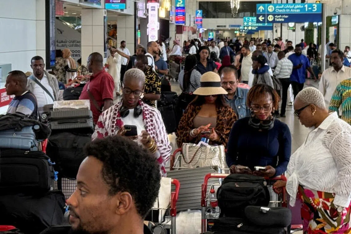 Passengers queue at Dubai International Airport in Dubai, United Arab Emirates, on June 24.