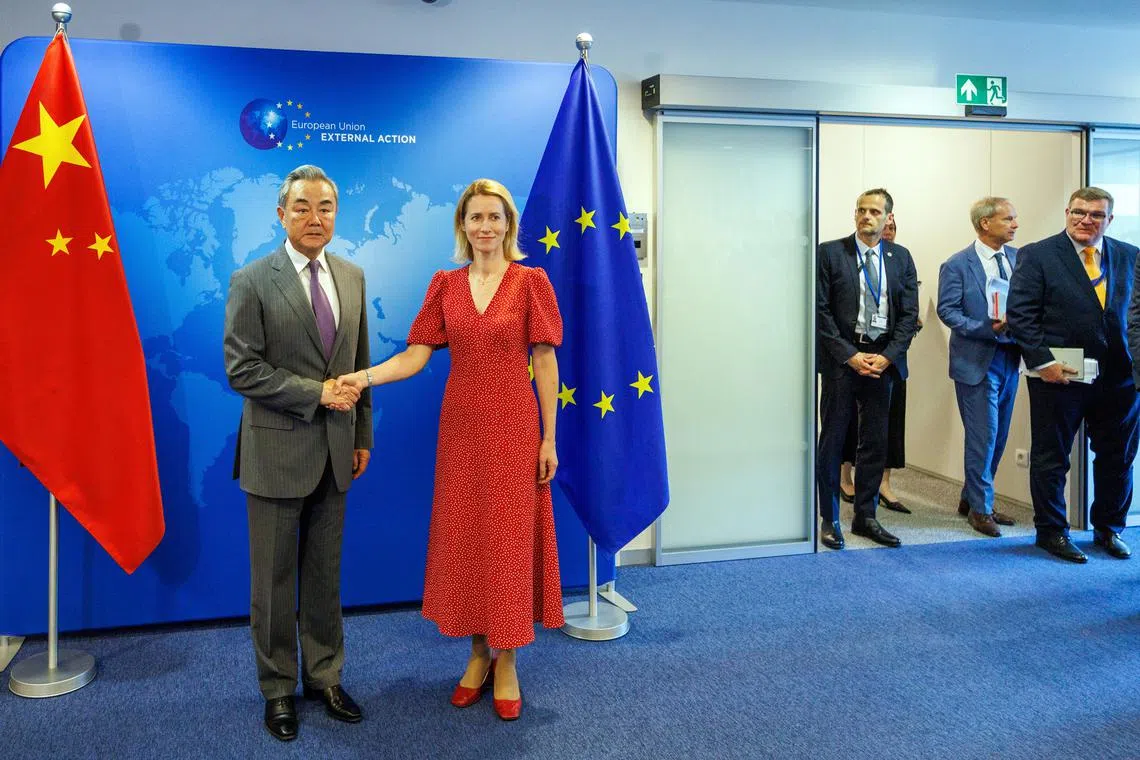 EU's top diplomat Kaja Kallas (right) shakes hands with Chinese Foreign Minister Wang Yi in Brussels on July 2.