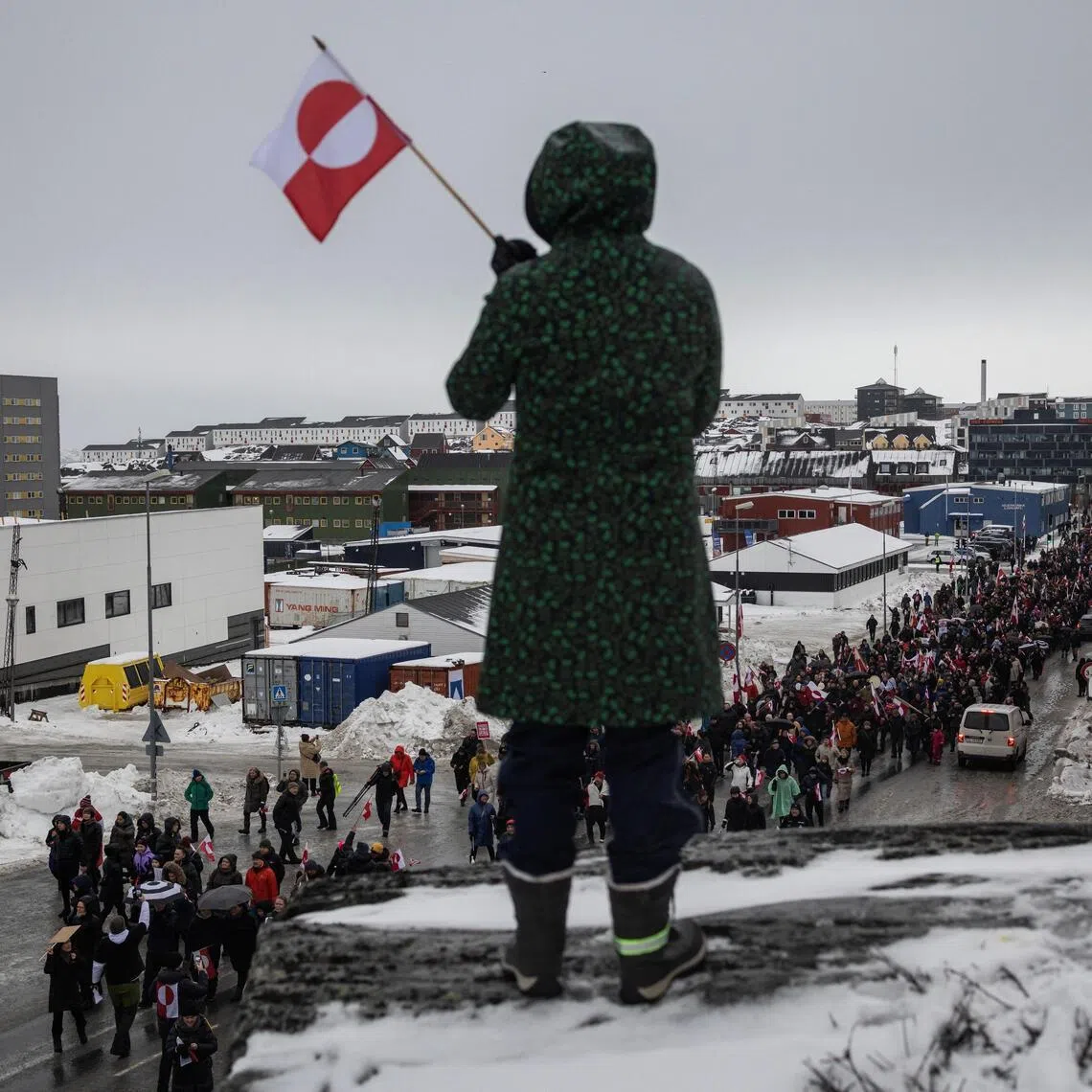 A woman waves a Greenlandic flag as people attend a protest against US President Donald Trump's demand that the Arctic island be ceded to the United States.
