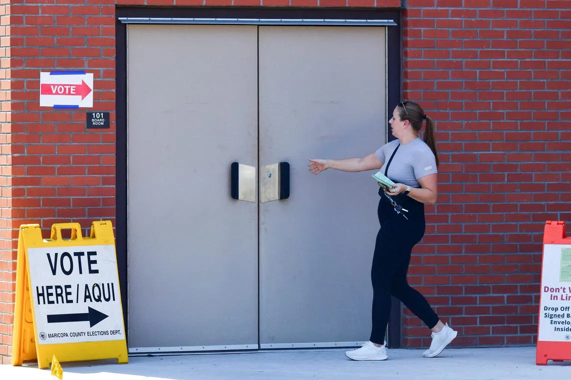 FILE PHOTO: A voter walks into a polling location with an early ballot at Osborn Elementary School in Phoenix, Arizona, U.S., July 30, 2024. REUTERS/Caitlin O'Hara/File Photo