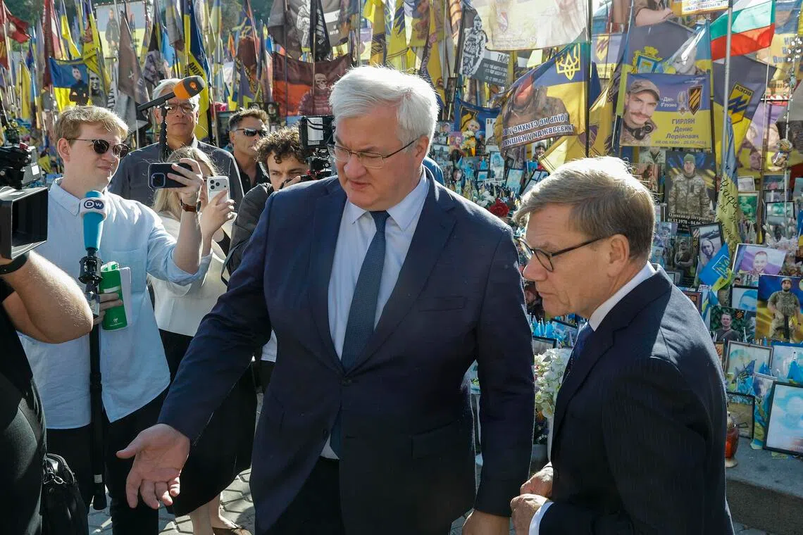 Ukrainian Foreign Minister Andrii Sybiha (left) and German Foreign Minister Johann Wadephul visiting a memorial site for fallen Ukrainian servicemen and international volunteers in Kyiv, Ukraine, on Aug 22.