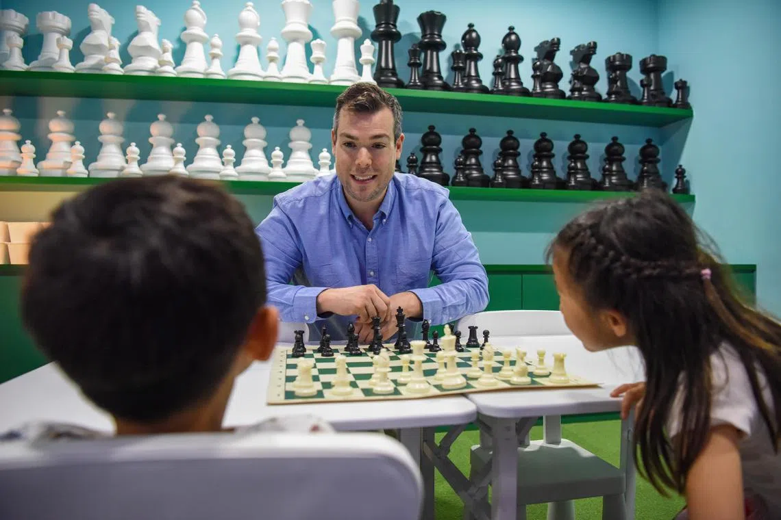 Chess At Three's co-founder and chief executive, Mr Jon Sieber, playing chess with students, Zen Sun, five, and his six-year-old sister Zigsa.