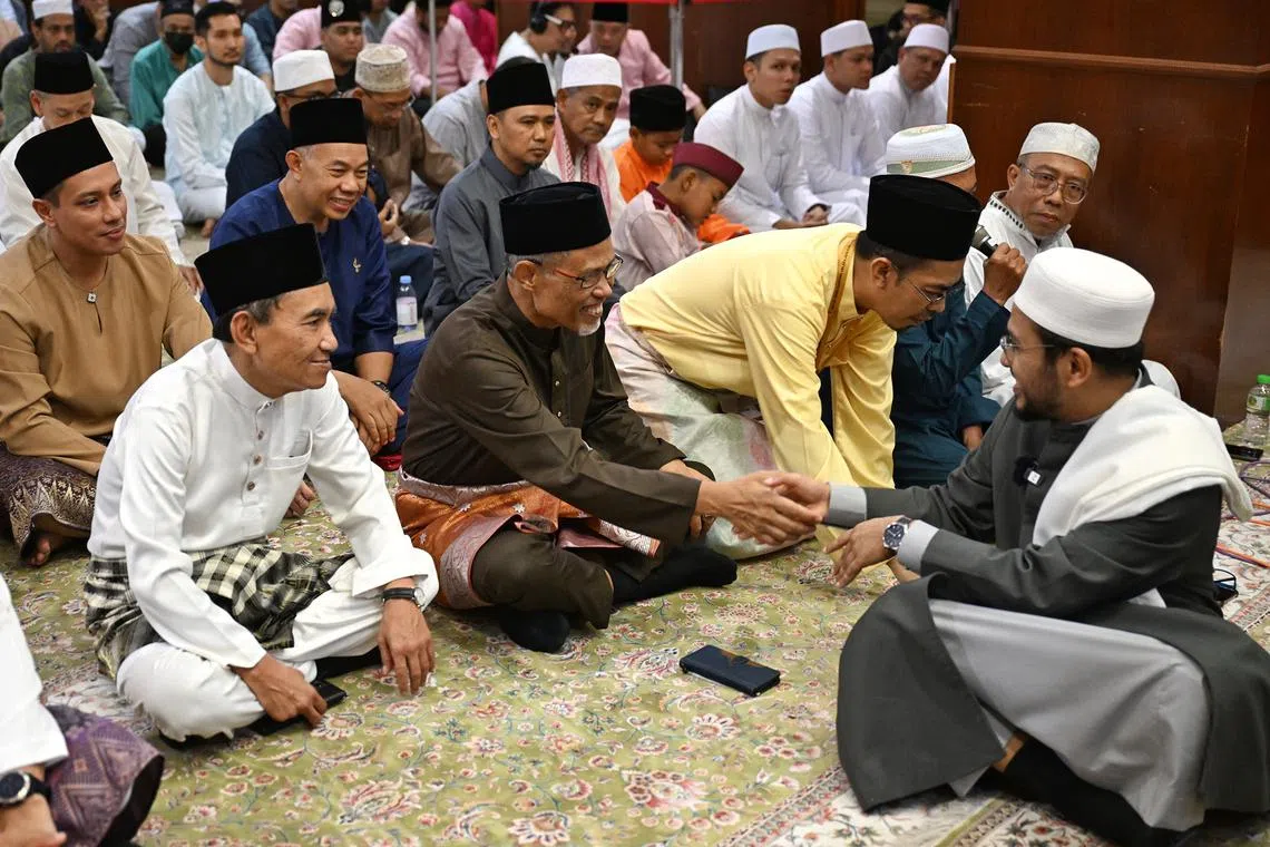 Mr Masagos Zulkifli, Minister for Social and Family Development, Second Minister for Health and Minister-in-charge of Muslim Affairs (second from left), greeting the Mufti, Dr Nazirudin Mohd Nasir, before the start of Hari Raya Aidilfitri prayers at Masjid Omar Kampong Melaka on April 10, 2024.