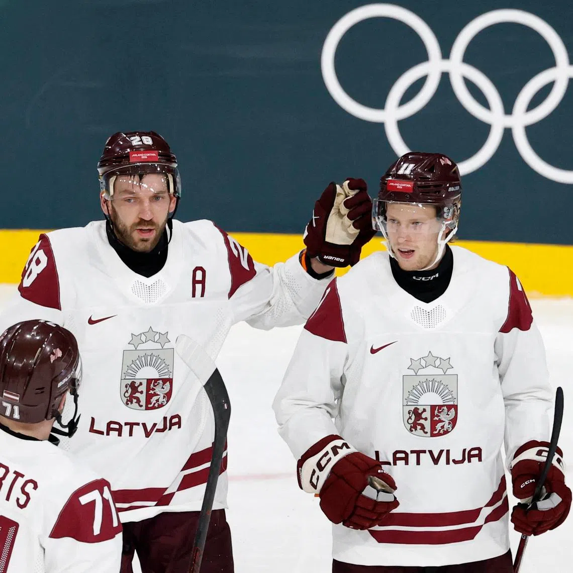 Milano Cortina 2026 Olympics - Ice Hockey - Men's Preliminary Round - Group C - Germany vs Latvia - Milano Rho Ice Hockey Arena, Milan, Italy - February 14, 2026. Dans Locmelis of Latvia celebrates scoring their second goal with Zemgus Girgensons and Roberts Bukarts REUTERS/David W Cerny