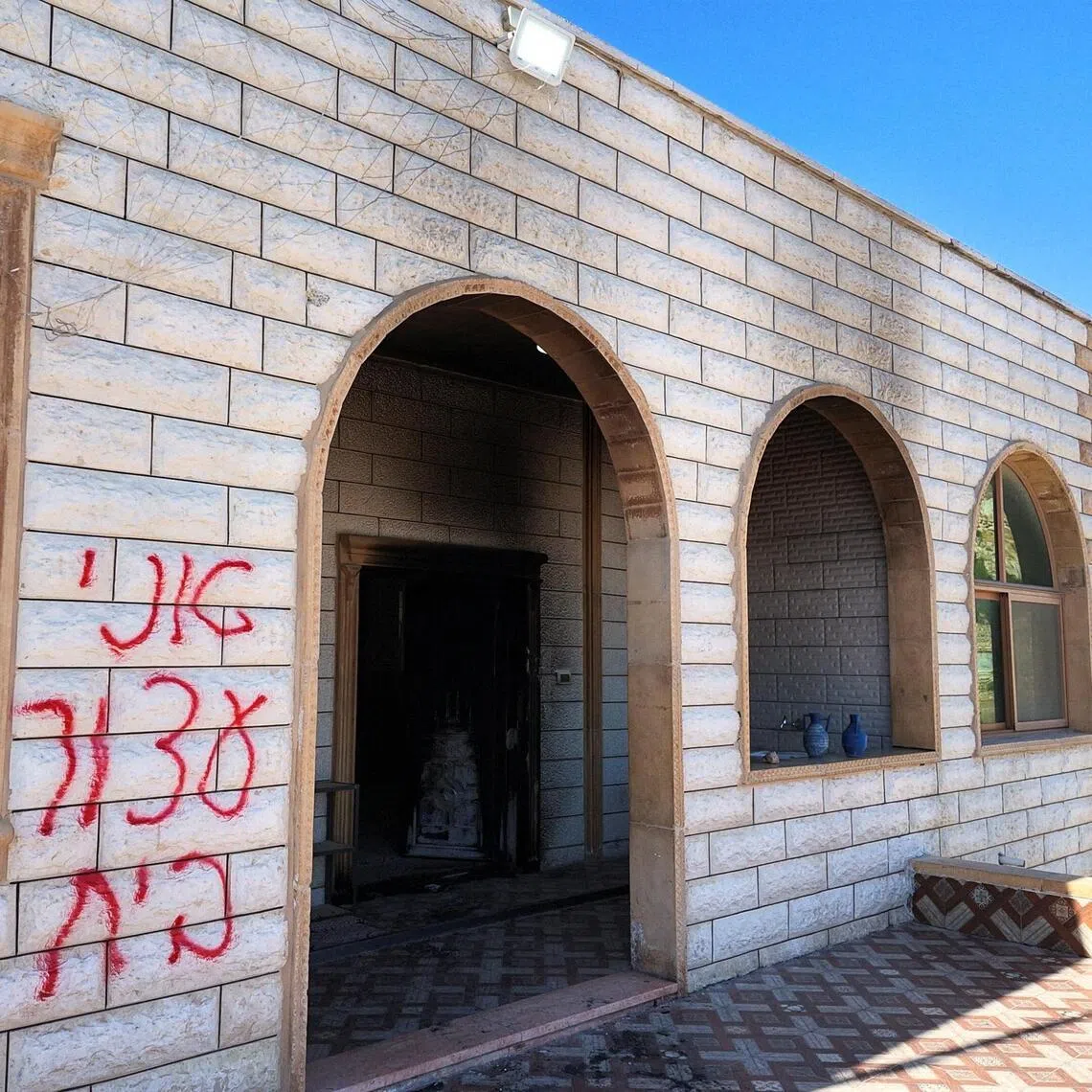 Graffiti spray-painted on the wall of a mosque, which Palestinians say was painted by Israeli settlers, in the Israeli-occupied West Bank on July 19.