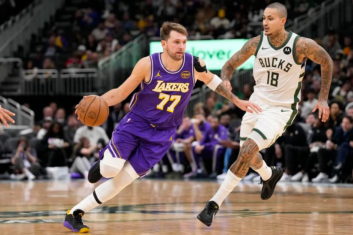 Los Angeles Lakers guard Luka Doncic drives towards the basket around Milwaukee Bucks forward Kyle Kuzma during the third quarter at Fiserv Forum. 