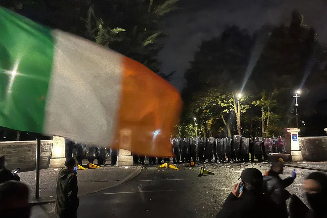 Protesters face a line of police at a demonstration outside a hotel housing asylum seekers in Saggart, south-west of Dublin in Ireland on Oct 21.