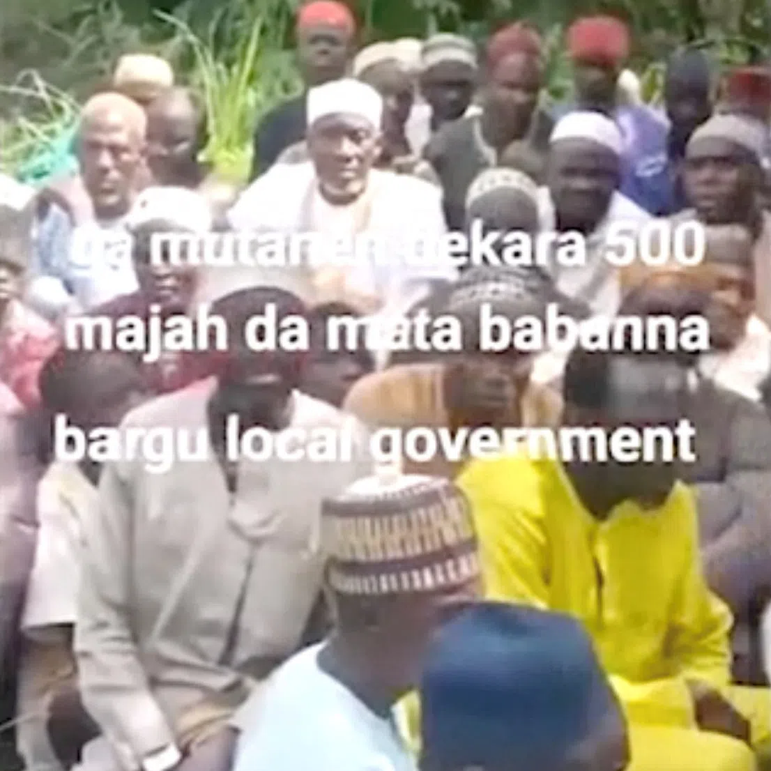 People sit on the grass in this screen grab obtained from a social media video released by an armed group on August 23, 2026, showing what residets said were about 600 women, children and older people abducted in an attack on a mosque in Nigeria’s north-central Niger State. SOCIAL MEDIA/via REUTERS