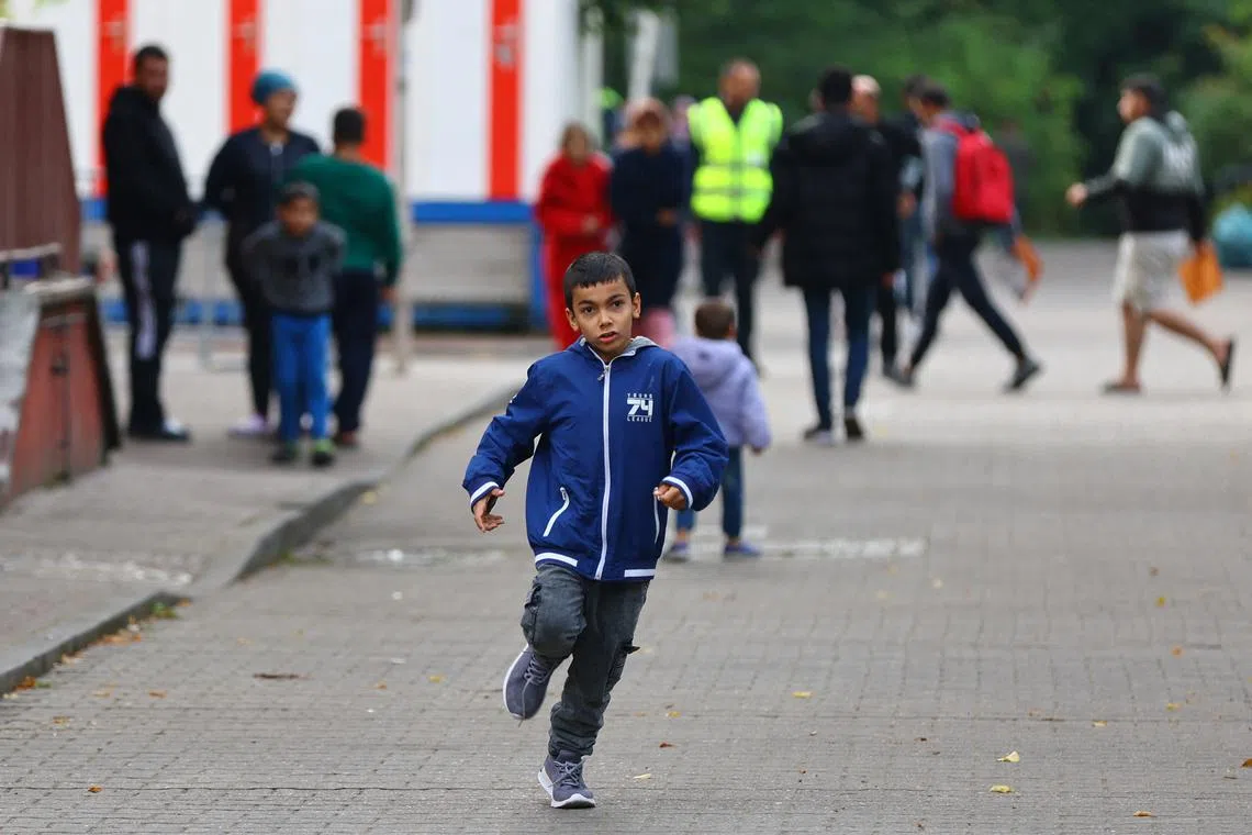FILE PHOTO: A boy runs outside the registration area for migrants at the arrival center for asylum seekers at Berlin's Reinickendorf district, Germany, October 6, 2023. REUTERS/Fabrizio Bensch/File Photo
