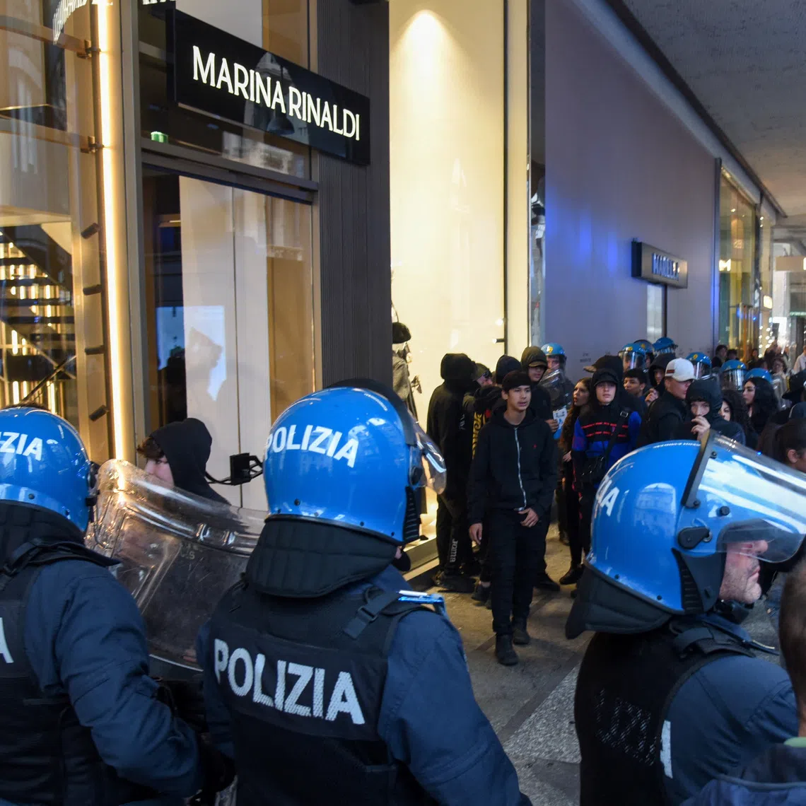 Italian police facing a crowd during a protest over the state of public services and the rising cost of living in Milan on Oct 18.