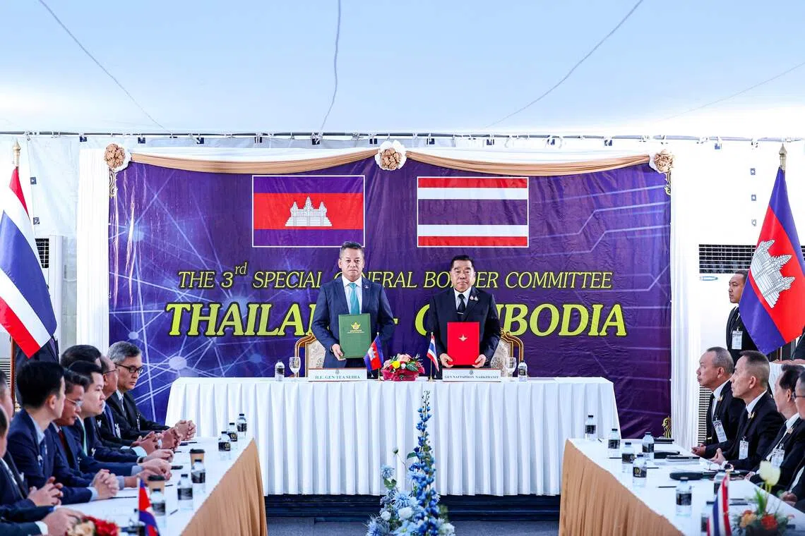 Cambodia's Defence Minister Tea Seiha (left) and Thailand's Defence Minister Nattaphon Narkphanit posing with documents during the special General Border Committee meeting on Dec 27.