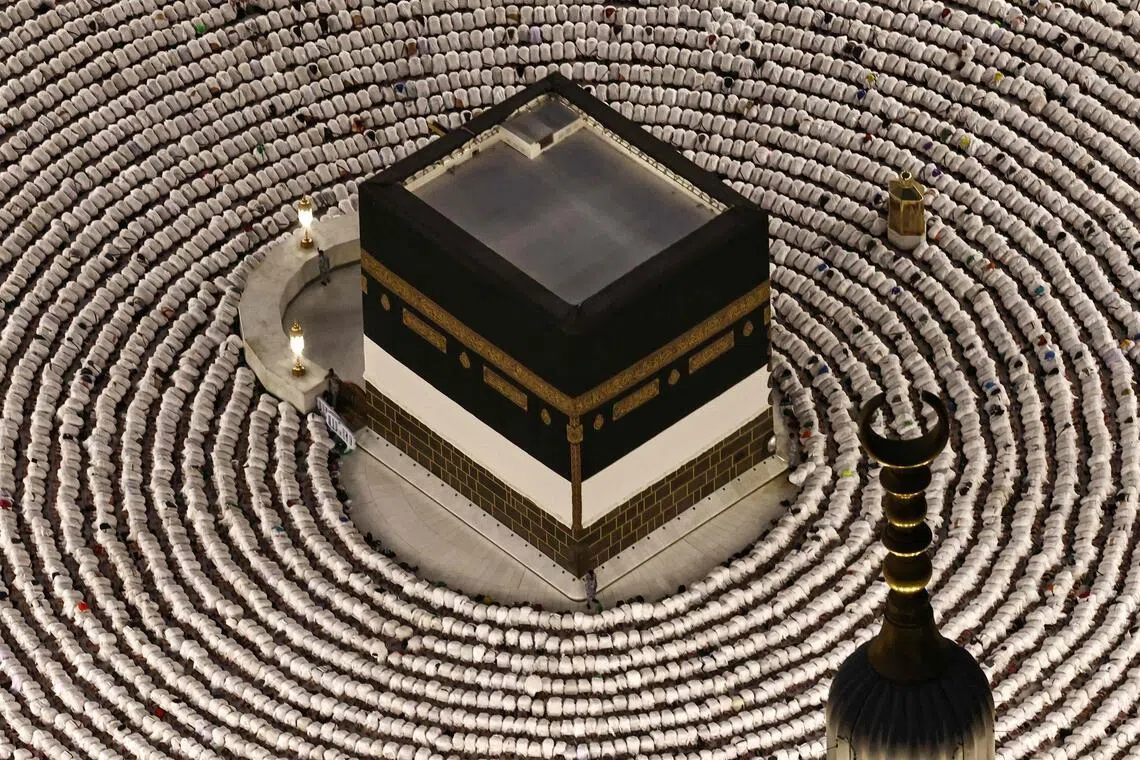 TOPSHOT - Muslims perform the evening prayer around the Kaaba, Islam's holiest shrine, at Grand Mosque complex on May 24, 2026, ahead of the annual Hajj pilgrimage. Over 1.5 million pilgrims have arrived in Saudi Arabia from outside the kingdom for the upcoming hajj, according to a Saudi official, exceeding the number of international visitors last year despite the war in the Middle East. (Photo by Zain JAAFAR / AFP)