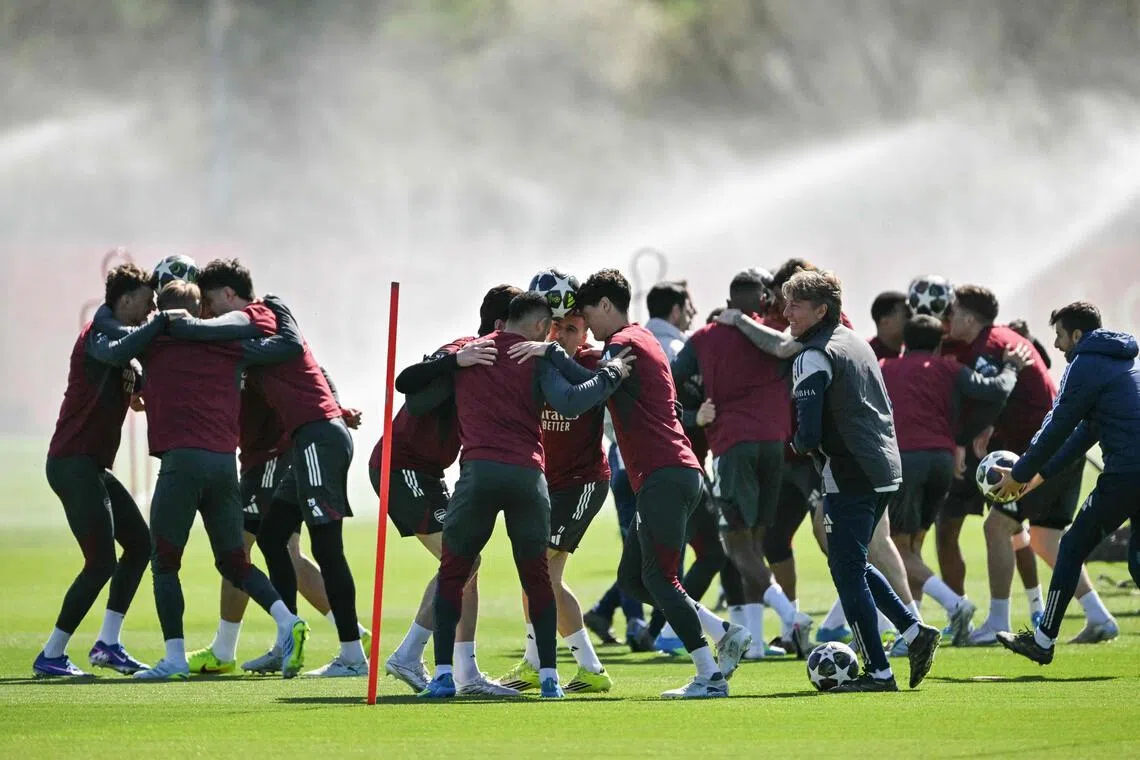 Arsenal players try to transport the ball without dropping it as they take part in a training session on the eve of their UEFA Champions League quarter-final, first-leg football match against Sporting in Portugal.