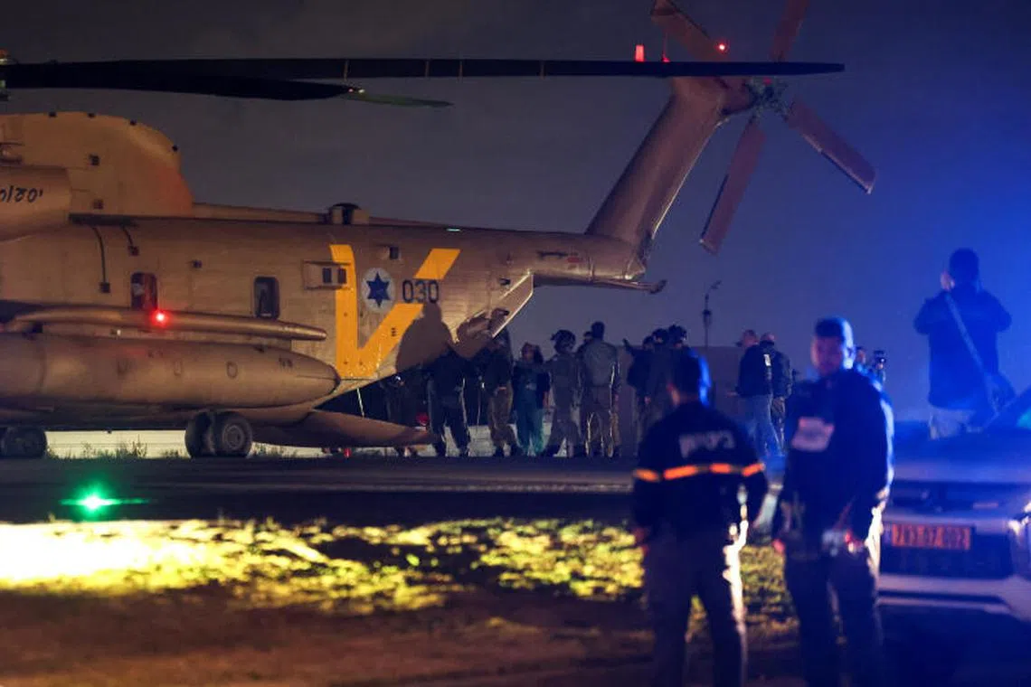 People walk near the Israeli military helicopter, as Romi Gonen, Doron Steinbrecher and Emily Damari, three female hostages who have been held in Gaza since the deadly October 7 2023 attack, return to Israel as part of a ceasefire deal in Gaza between Hamas and Israel, at Sheba Medical Center in Ramat Gan, Israel January 19, 2025. REUTERS/Ronen Zvulun