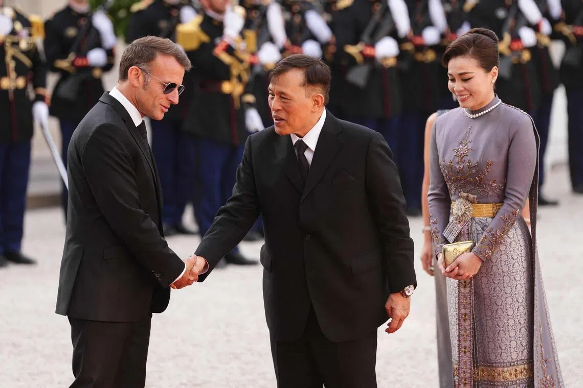 France's President Emmanuel Macron (L) greets Thailand's King Maha Vajiralongkorn (C) and Thailand's Queen Suthida (R) as they arrive at The Elysee Presidential Palace for a working dinner as part of the Thai King's State visit to France, in Paris on June 29, 2026. (Photo by Dimitar DILKOFF / AFP)