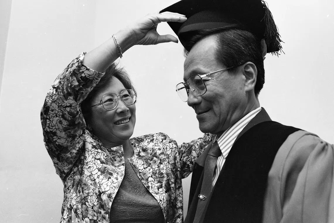 Mrs Lim Chong Yah helping her husband, a noted local economist, dress for the presentation ceremony. Professor Lim Chong Yah was awarded the highest honour of Professor Emeritus at the opening session of the National University of Singapore convocation on 31 August 1992.