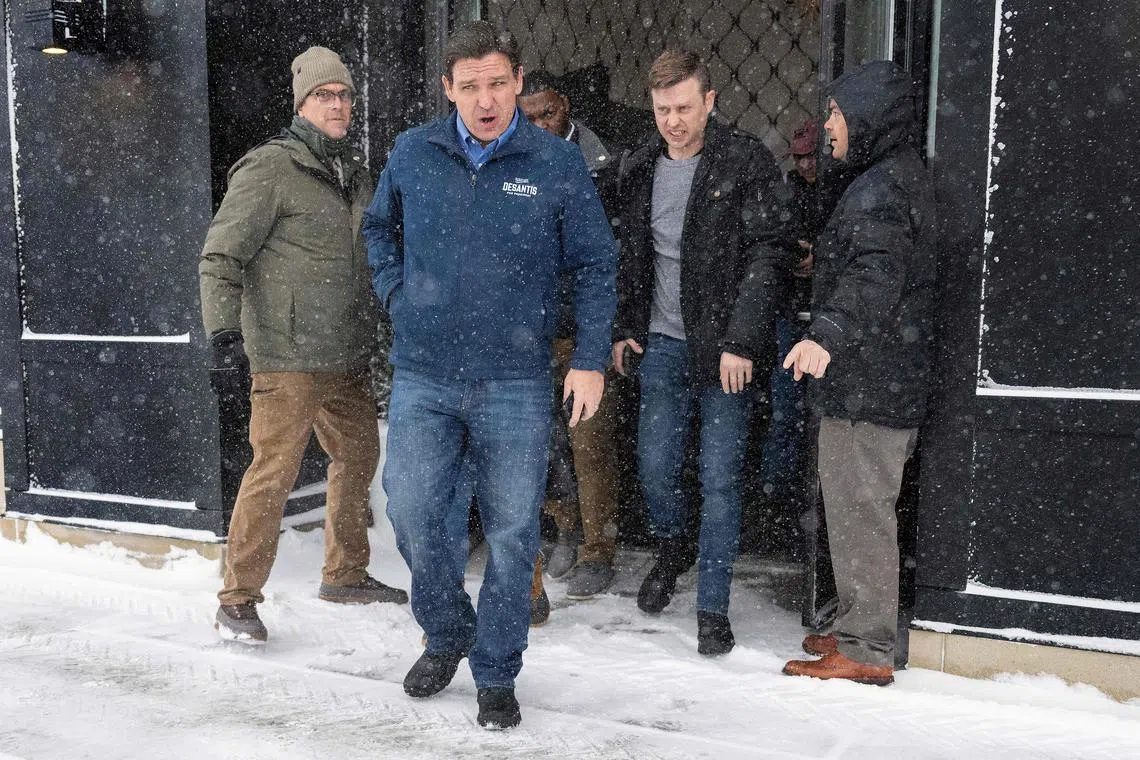 Florida Governor and 2024 Republican presidential hopeful Ron DeSantis (centre) is guided to his vehicle by staff as he departs a campaign stop in Ankeny, Iowa.