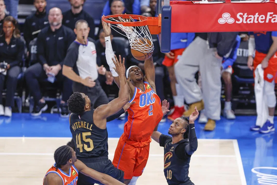 Oklahoma City Thunder guard Shai Gilgeous-Alexander dunks between Cleveland Cavaliers guards Darius Garland and Donovan Mitchell during the fourth quarter at Paycom Centre.