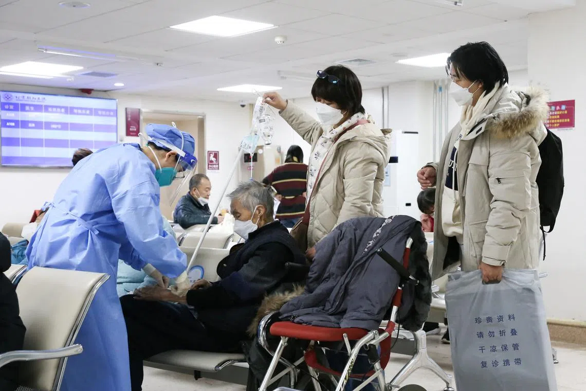 A medical worker administers an IV drip treatment for a patient at the fever clinic of Beijing Chaoyang hospital on Dec 27, 2022. 