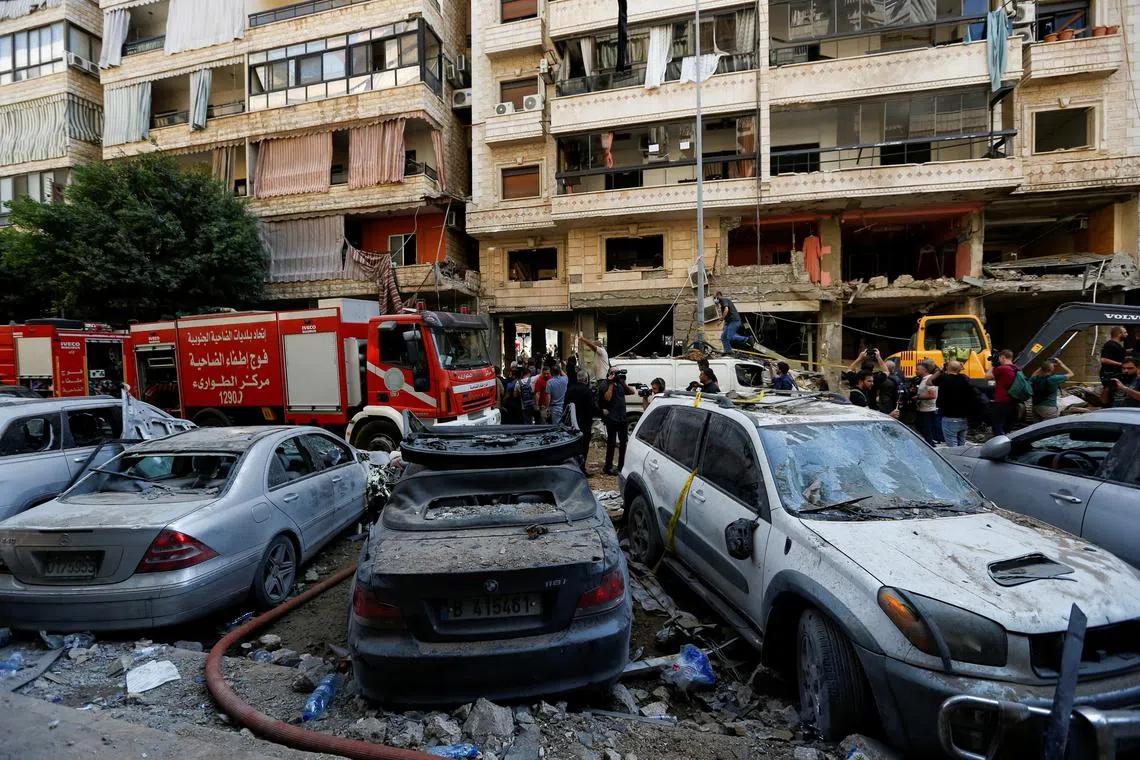 People gather near a firetruck and damaged vehicles at the site of Friday's Israeli strike, as search and rescue operations continue, in Beirut's southern suburbs, Lebanon September 21, 2024. REUTERS/Amr Abdallah Dalsh