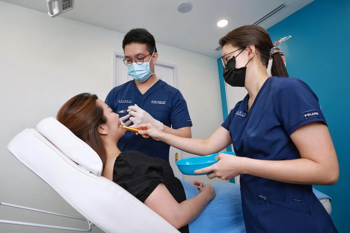 Dr Pek Chong Han (centre) conducting a demonstration of a procedure on a ‘patient’ at Polaris Plastic and Reconstructive Surgery.