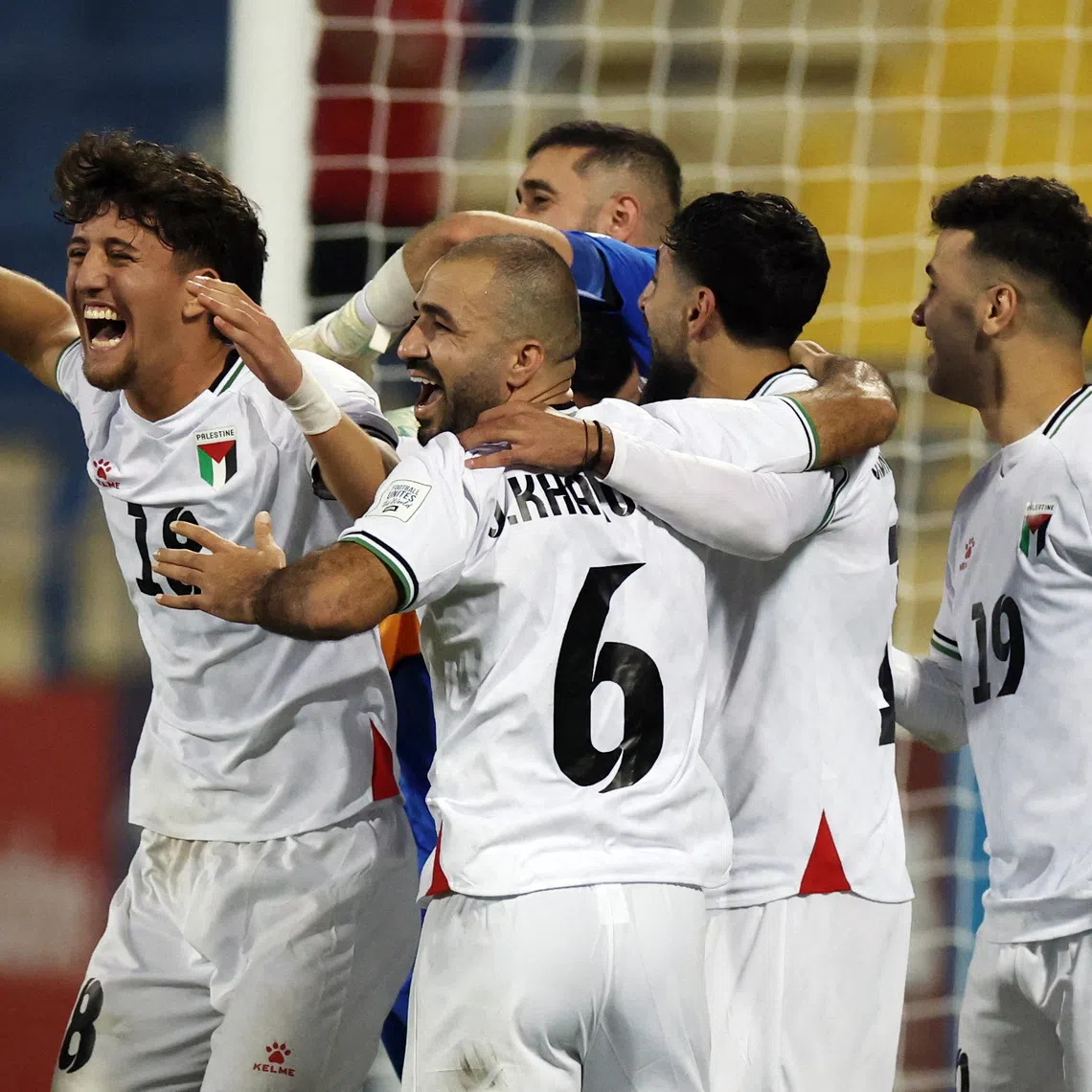 Soccer Football - FIFA Arab Cup - Qatar 2025 - Qualifying - Palestine v Libya - Thani bin Jassim Stadium, Al Rayyan, Qatar - November 25, 2025 Palestine's Oday Kharoub and Ahmad Al Qaq celebrate with teammates after winning the penalty shootout REUTERS/Mohammed Salem