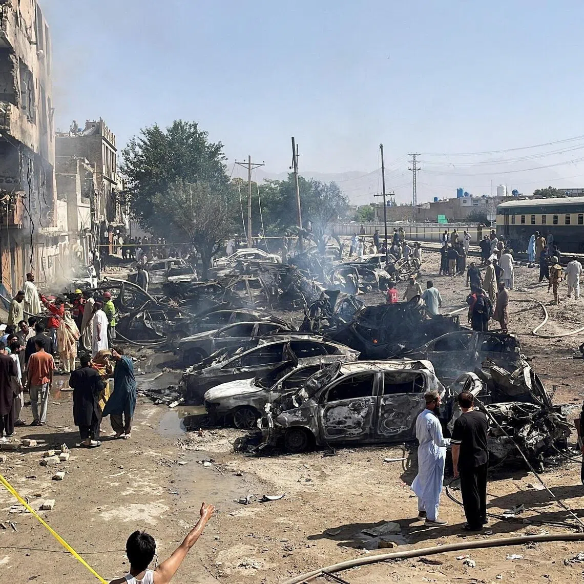 People and police officers gather after a blast near a railway track in Quetta, Pakistan, on May 24.