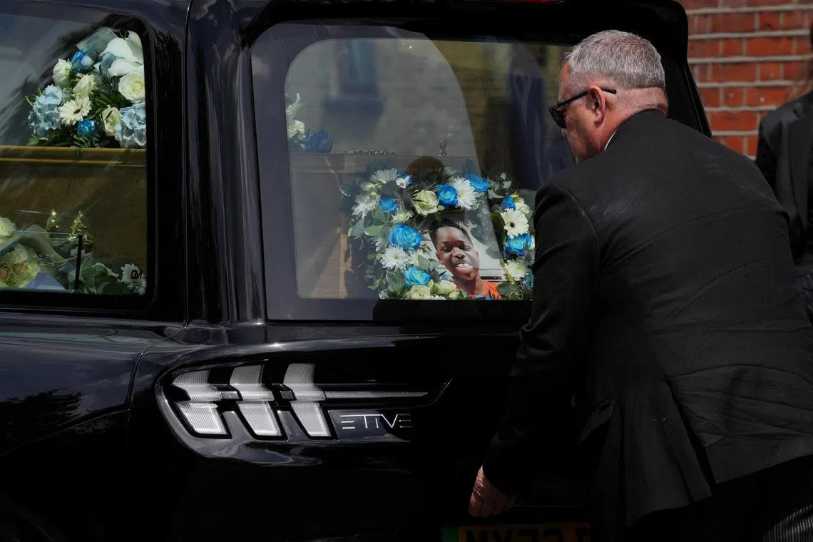 FILE PHOTO: A floral tribute and photograph placed behind the coffin of Daniel Anjorin, 14, following his funeral service at Jubilee Church in Ilford, east London, Britain. Jonathan Brady/Pool via REUTERS/ File Photo