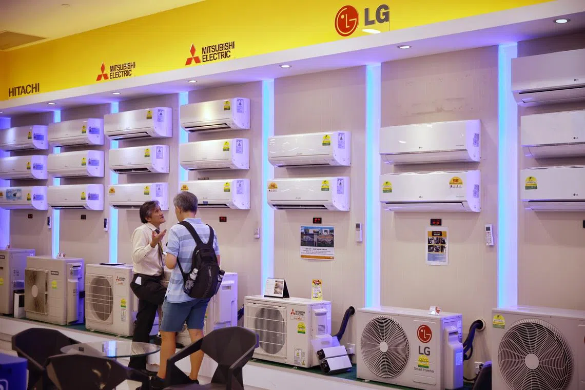 A salesman assisting a customer looking at air-con units at the Gain City megastore in Sungei Kadut on May 17, 2023.