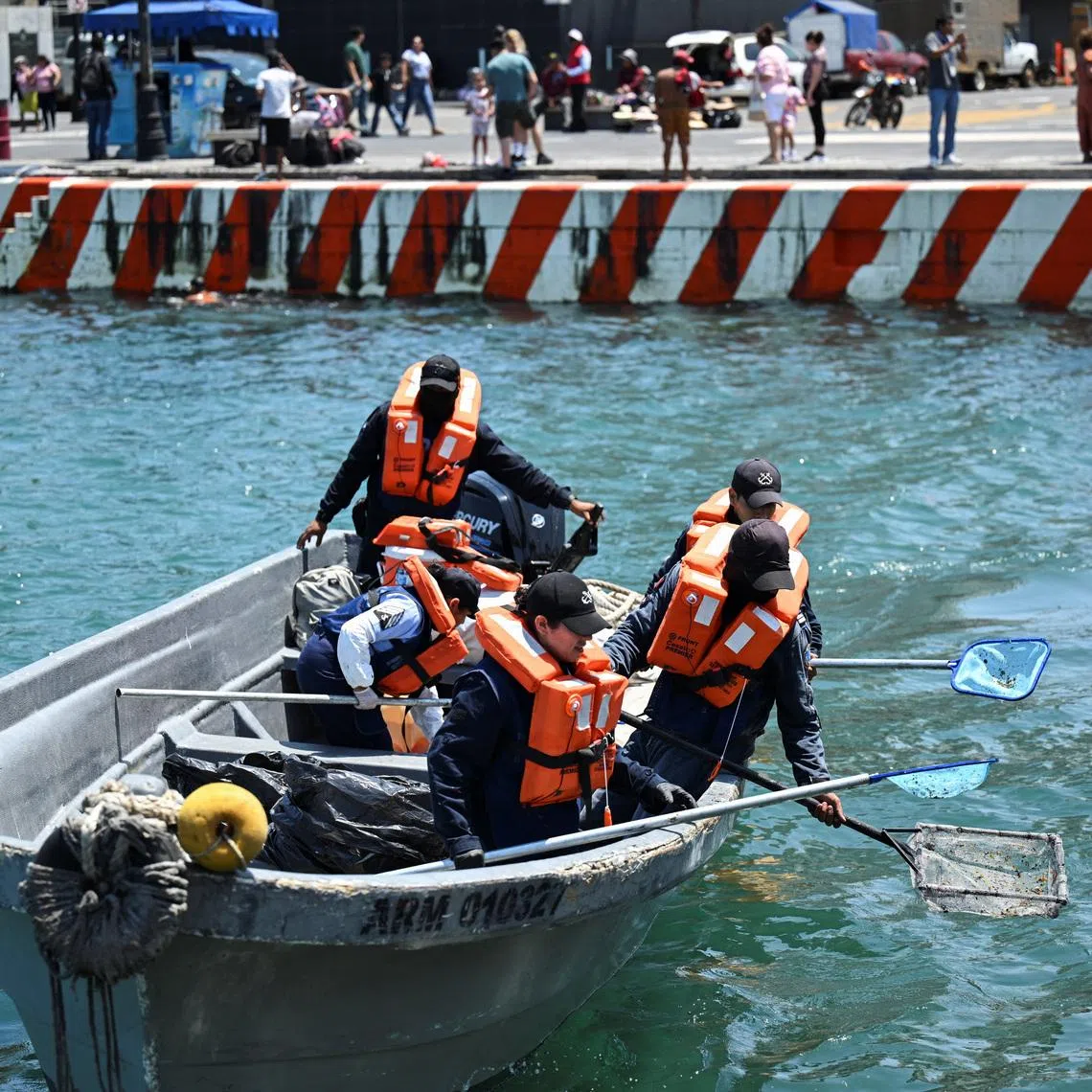 Members of the Mexican navy clean black tar slicks from the shoreline, amid local fears that more crude oil could wash ashore nearly a month after the first signs of contamination were detected in the states of Veracruz and Tabasco, in Veracruz, Mexico, March 26, 2026. REUTERS/Yahir Ceballos