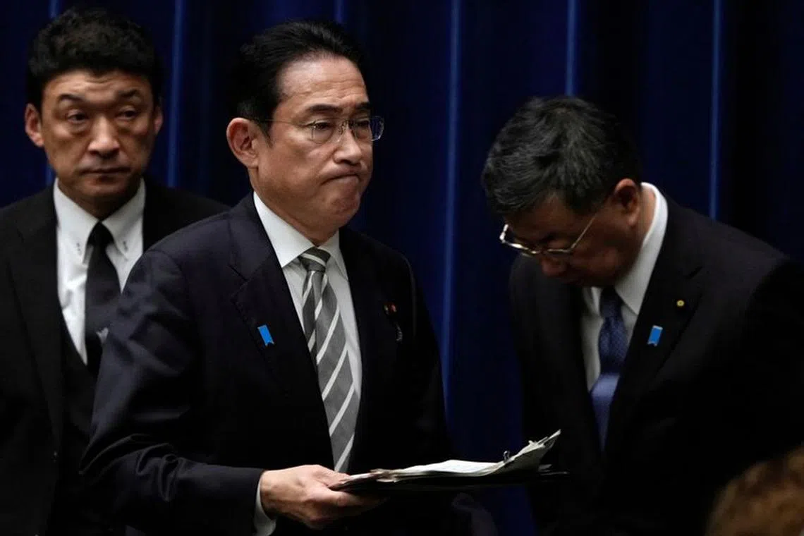 Japanese Prime Minister Fumio Kishida walks past Chief Cabinet Secretary Hirokazu Matsuno at the end of a news conference at the prime minister's office in Tokyo, Japan, 13 December 2023. Prime Minister Kishida said he will replace several ministers implicated in a political fundraising scandal.    FRANCK ROBICHON/Pool via REUTERS