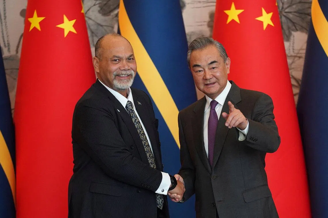Chinese Foreign Minister Wang Yi shaking hands with Nauru's Minister of Foreign Affairs and Trade Lionel Aingimea after signing the Joint Communiqué on the Resumption of Diplomatic Relations between China and Nauru, at Diaoyutai State Guesthouse in Beijing on Jan 24, 2024.  Nauru announced in the same month its switch of allegiance from Taiwan to China.