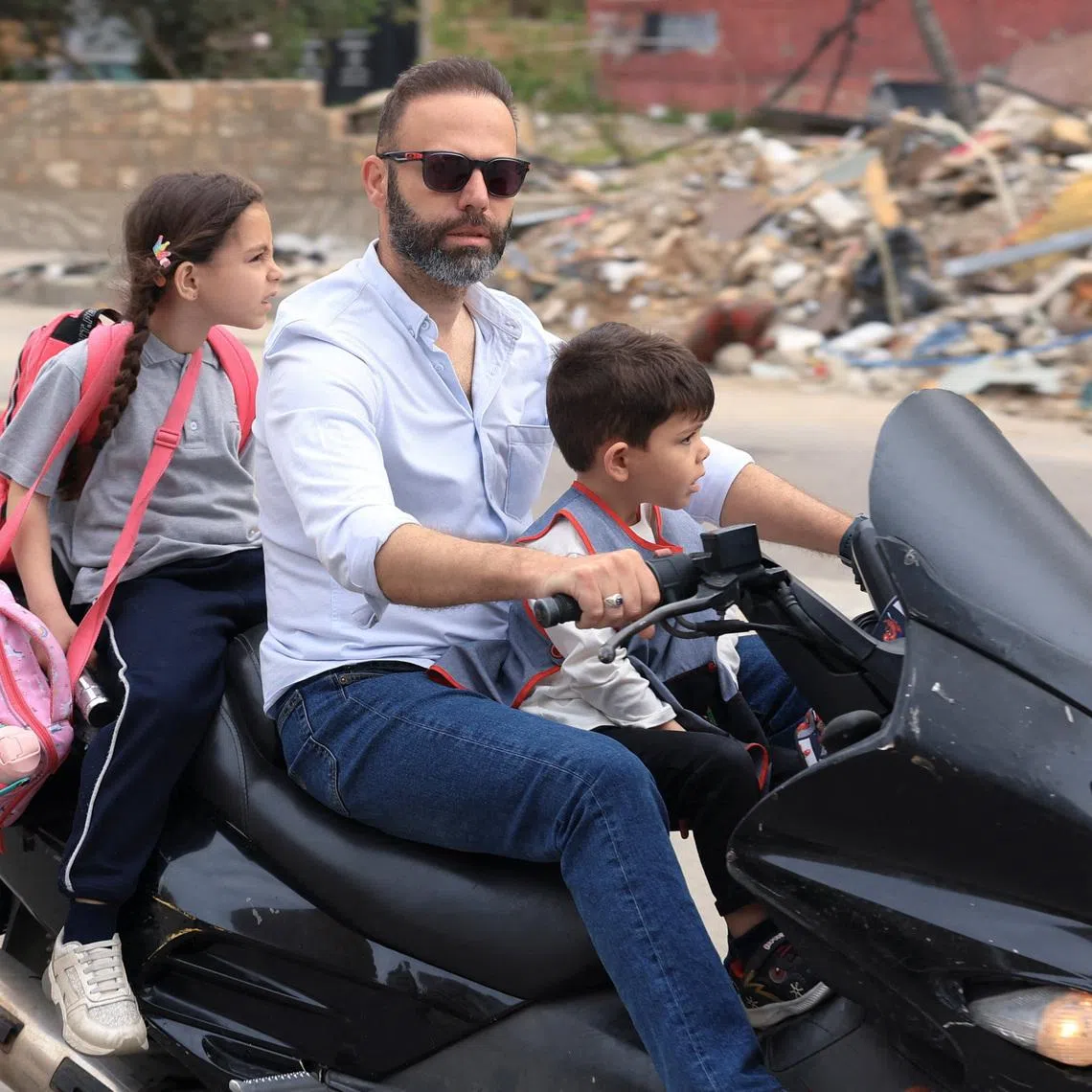 A man with his kids returns to the southern suburbs of Beirut, after a 10-day ceasefire between Lebanon and Israel went into effect, Lebanon, April 17, 2026. REUTERS/Adnan Abidi