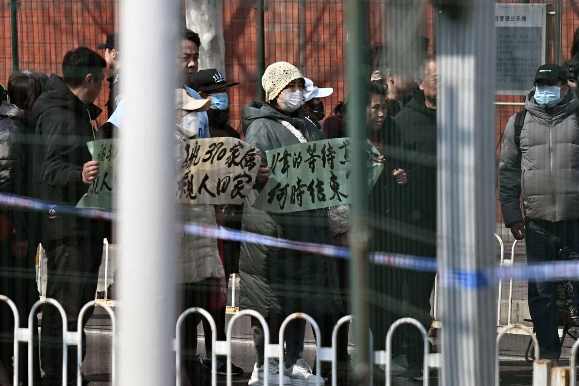 Relatives of passengers on board the missing Malaysia Airlines flight MH370 take part in a demonstration outside the Malaysian embassy in Beijing on March 8, 2025, on the 11th anniversary of the flight’s disappearance. (Photo by Pedro Pardo / AFP)