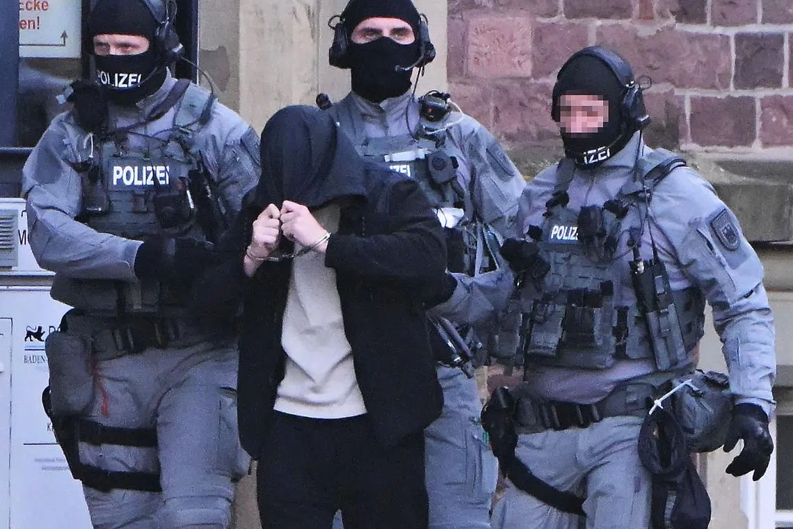 German police escort a suspected member of a militant group in Karlsruhe, southern Germany, on Nov 5.